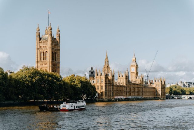 The UK Houses of Parliament are seen in the distance from the Victoria Tower end, looking from across the River Thames in the foreground