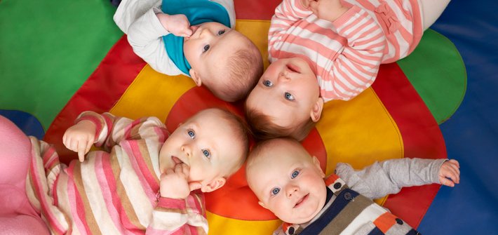 Overhead picture of two sets of twins lying on their backs