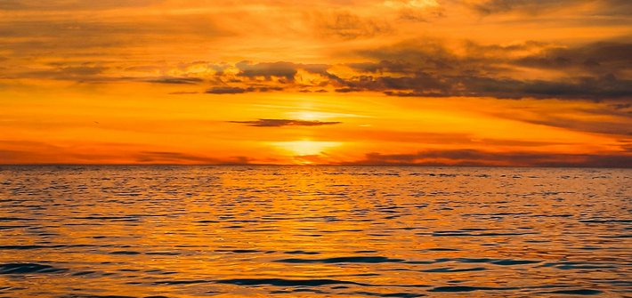 A sunset in the distance over a calm ocean