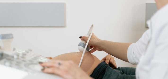Sonographer performs an ultrasound scan on a pregnant woman