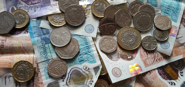 image of British pounds and small change on top of bank notes