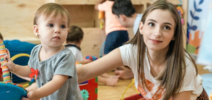 image of a toddler with a nursery teacher in a Montessori environment