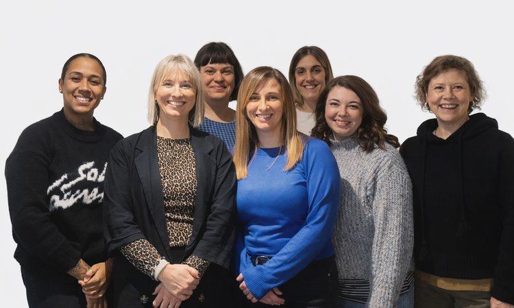 Posed photo of the members of the Family Services team stood together against a white background