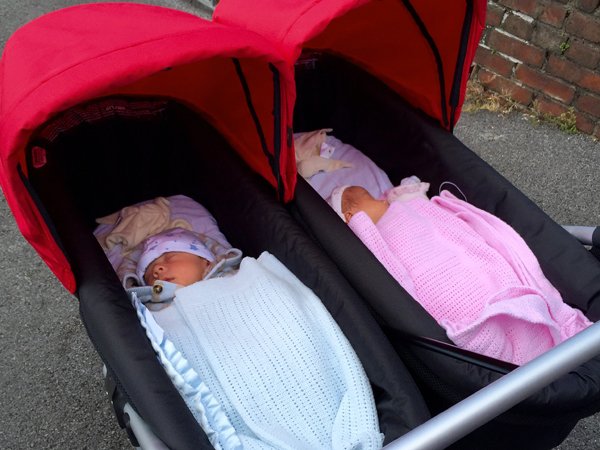 twin babies sleeping in a twin pram