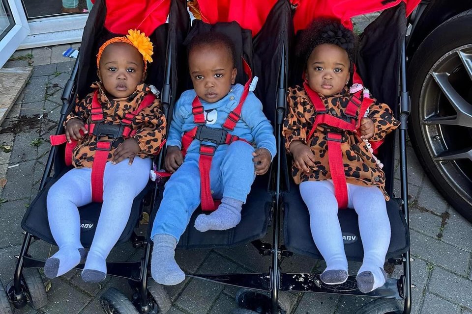 triplet toddlers in a triple pram