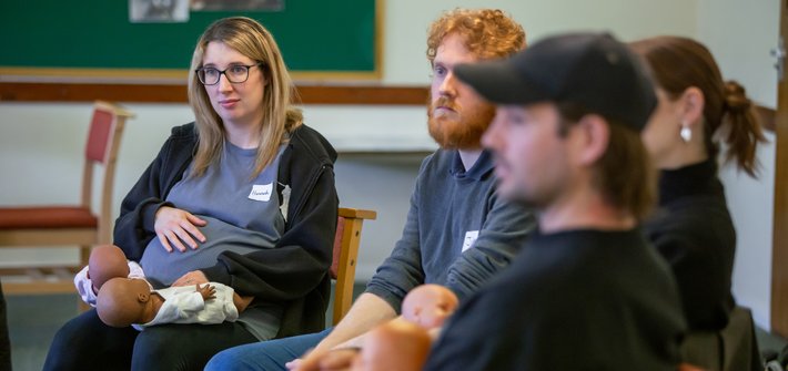 Two couples sit listening to someone speak off camera