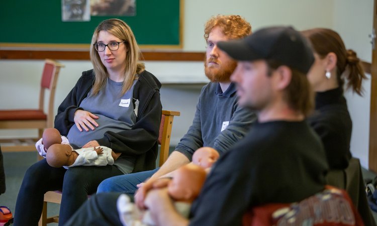 Two couples sit listening to someone speak off camera