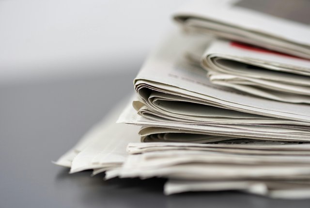 A close up image of a stack of newspapers taken from the side