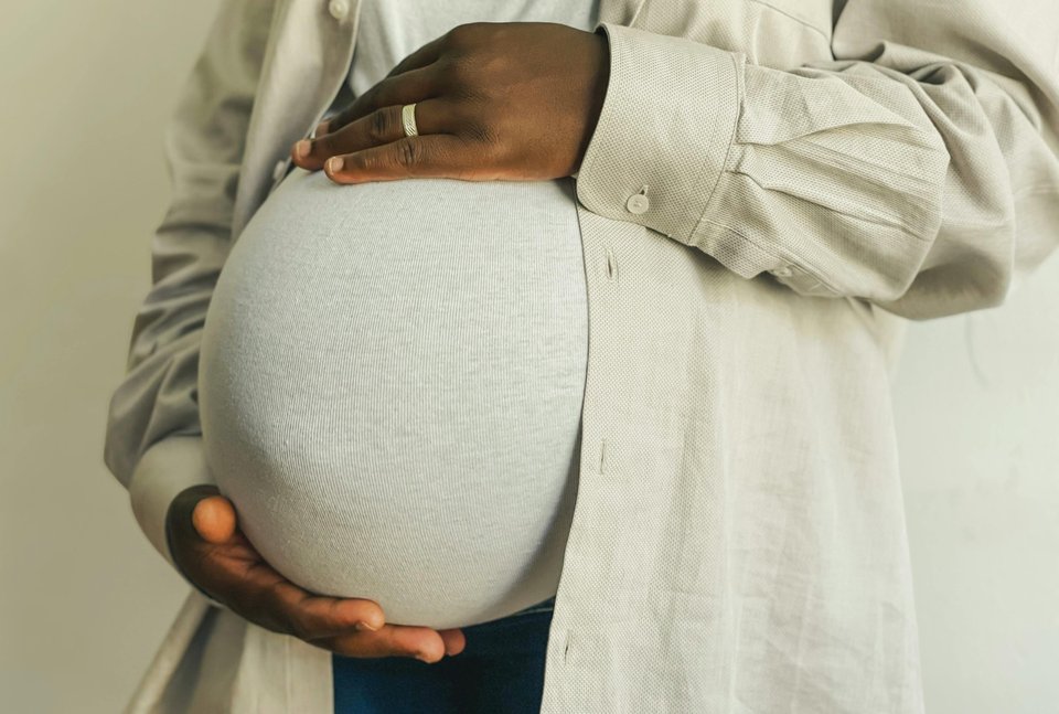 Close up image of a pregnant woman holding her belly