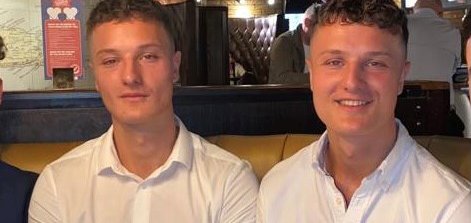 Identical twin men pose together