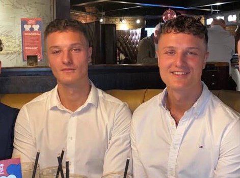 Identical twin men pose together