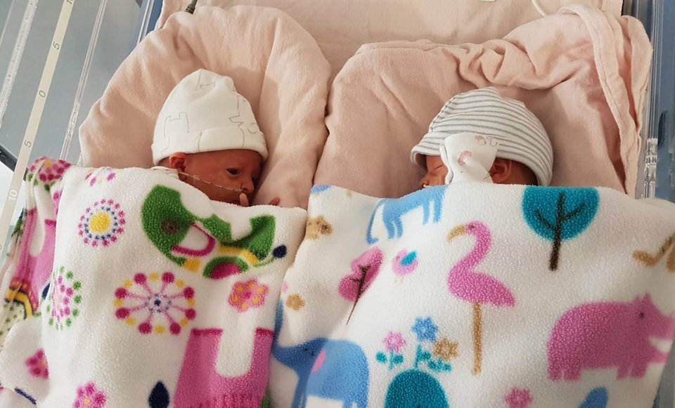 Twin babies sleeping next to each other