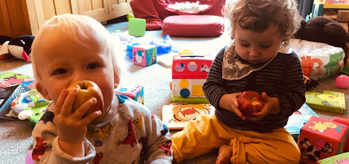 Young twins sit on the floor playing