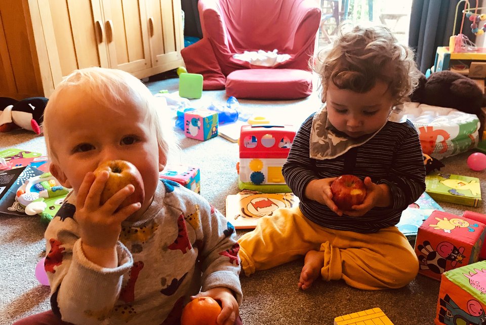 Young twins sit on the floor playing