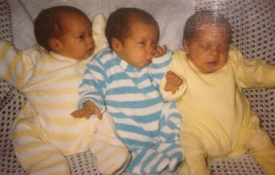 Triplet babies lie next to each other