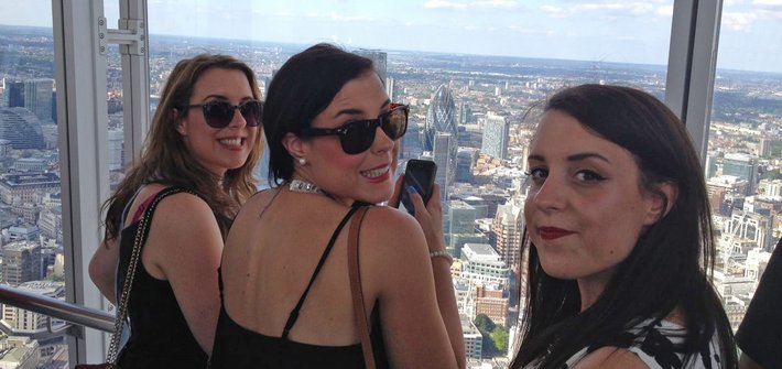 Adult triplet women in front of a London skyline