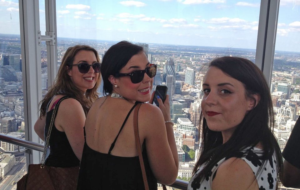 Adult triplet women in front of a London skyline