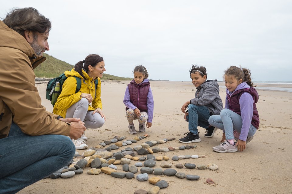 family of five making art in the sand