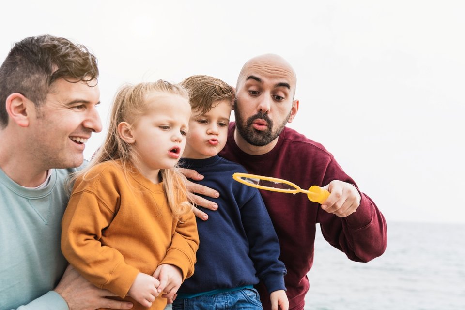 Lgbt family having fun with their children at the beach