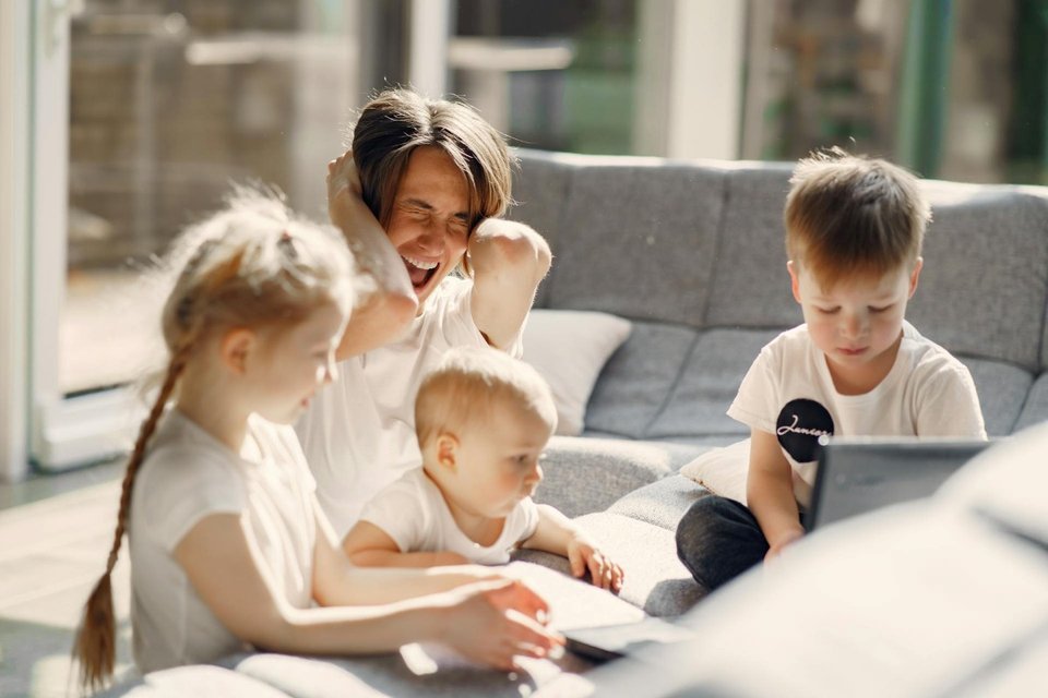 mother looking overwhelmed with small children at home