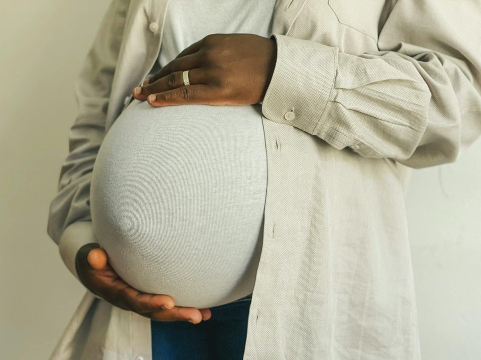 close up of a woman holding her pregnant abdomen