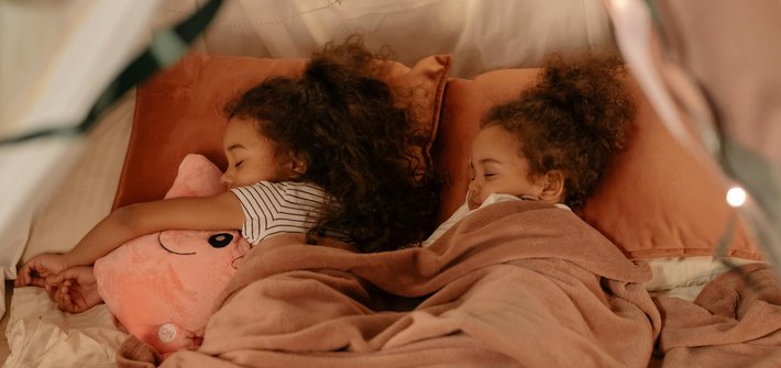 Twin girls sleep next to each other
