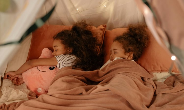 Twin girls sleep next to each other