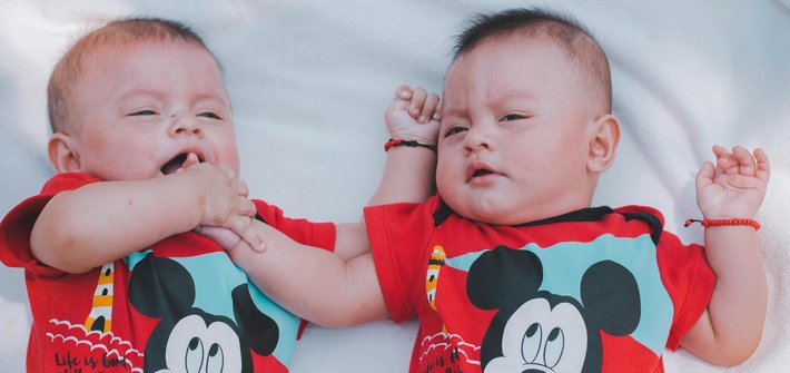 Twin babies lie next to each other