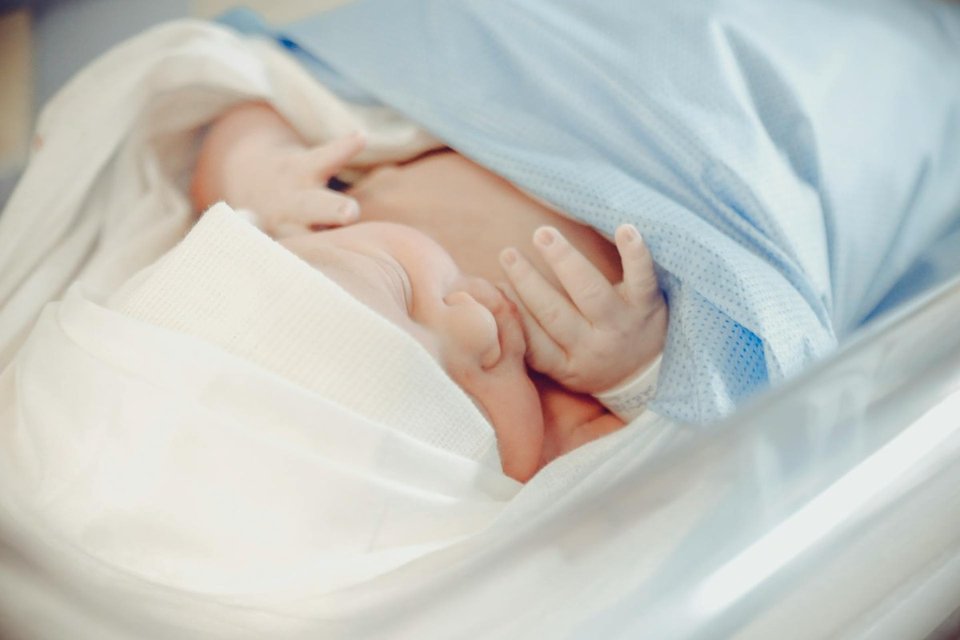 close up of a baby sleeping in a neonatal open crib