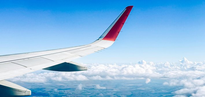 A plane wing flying high over land