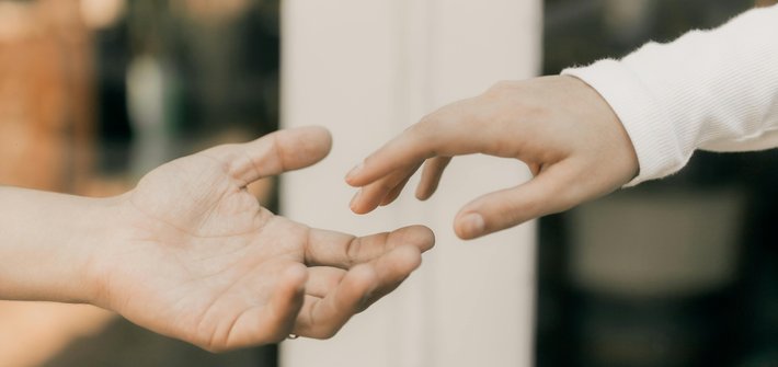Two hands reach out towards each other