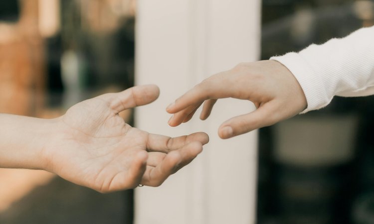 Two hands reach out towards each other