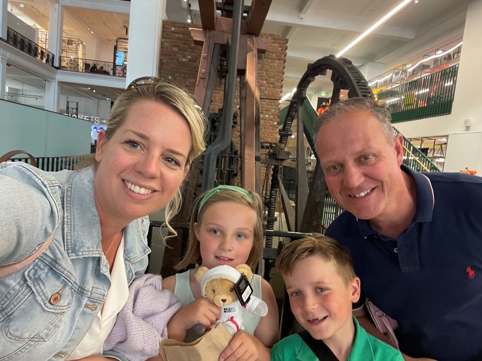 a mother and father with their twin boy and girl in a museum