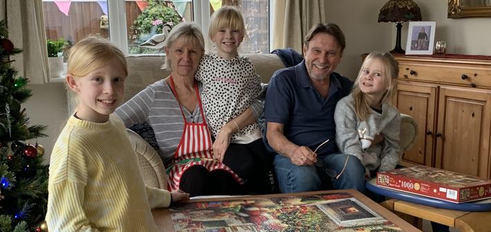 grandparents with three grandchildren completing a 1000 piece jigsaw puzzle