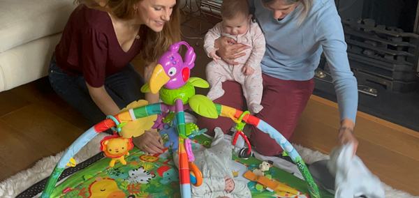a woman helping a mother with her twin babies