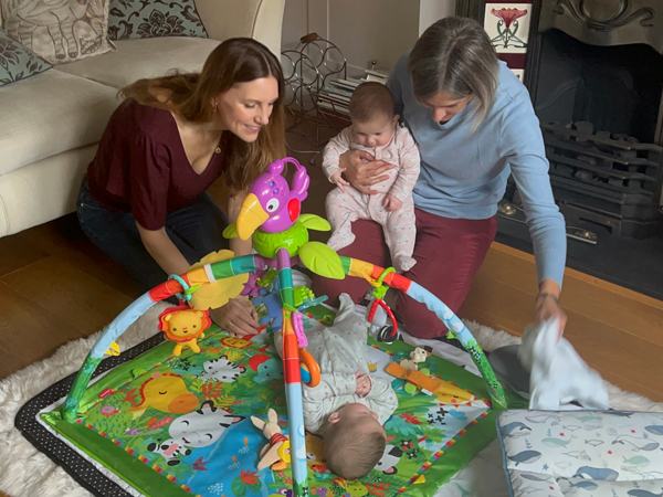 a woman helping a mother with her twin babies