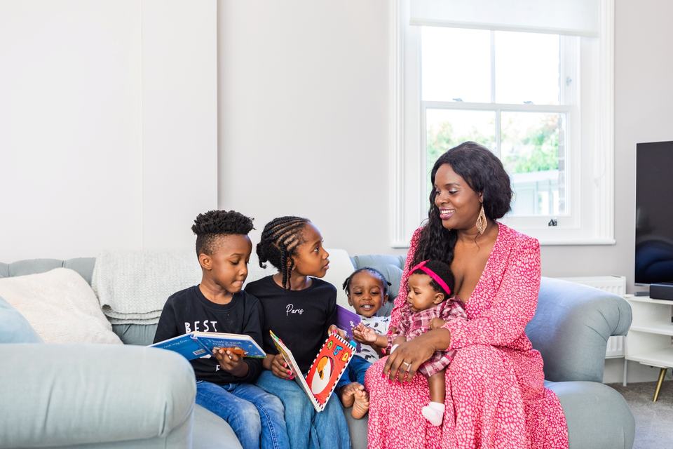 a mother and her four children reading on a sofa