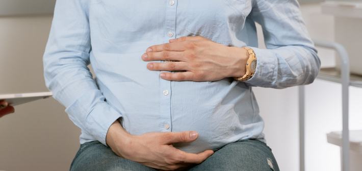a pregnant woman feeling her pregnant tummy
