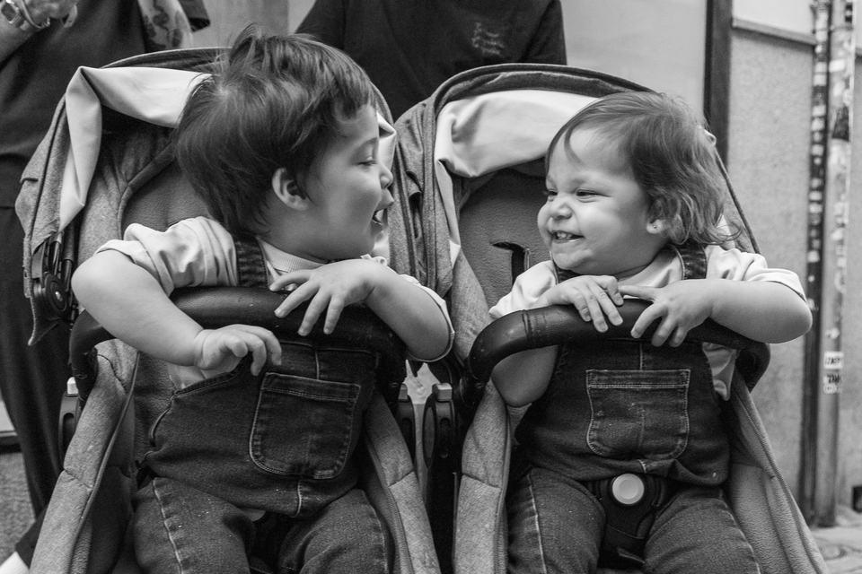 twin toddlers in a side-by-side buggy