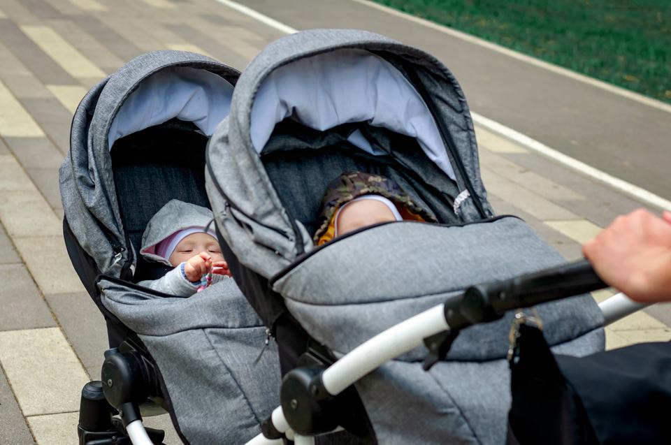 twin babies in a tandem double buggy