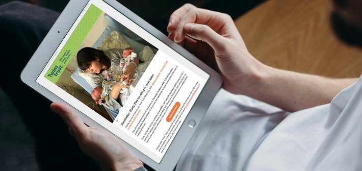 An overhead shot of a person using a tablet computer, cropped so that the person's torso and arms are visible